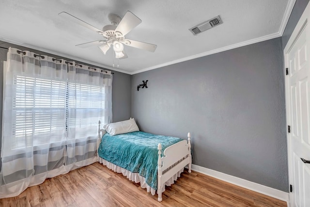 611 Storey Ave, Midland, TX 79703 - bedroom with wood finished floors, crown molding, baseboards, a ceiling fan, and a textured wall