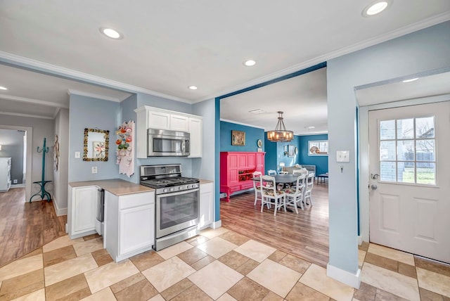 611 Storey Ave, Midland, TX 79703 - kitchen with stainless steel appliances, recessed lighting, crown molding, white cabinets, and light countertops