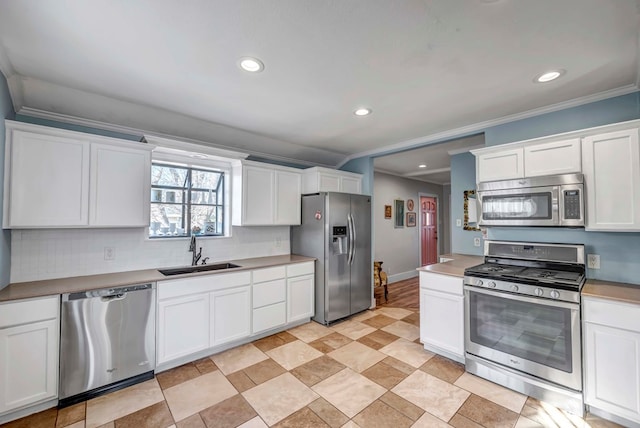 611 Storey Ave, Midland, TX 79703 - kitchen with stainless steel appliances, a sink, recessed lighting, white cabinetry, and crown molding