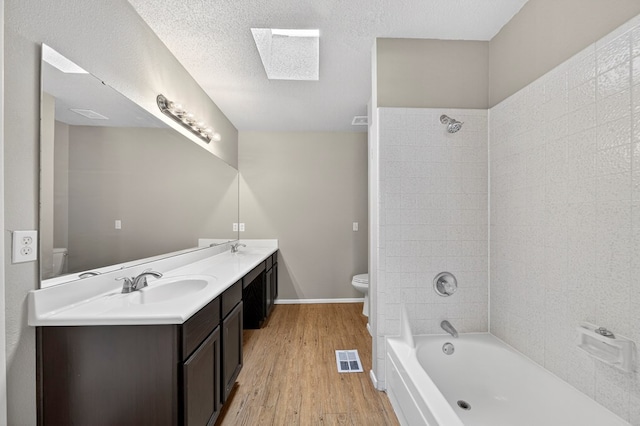 3237 Preston Dr, Midland, TX 79707 - bathroom with a skylight, double vanity, wood finished floors, and bathing tub / shower combination