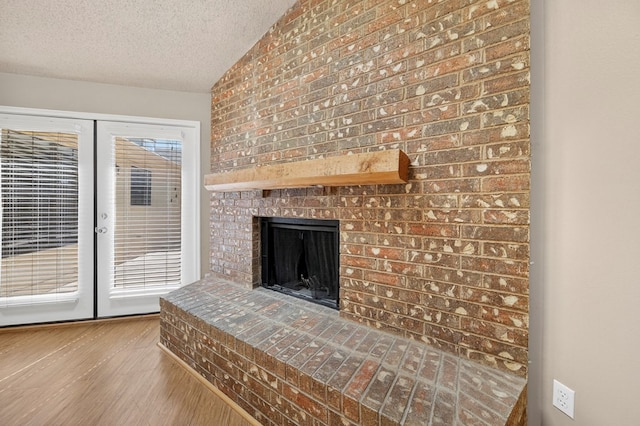 3237 Preston Dr, Midland, TX 79707 - unfurnished living room with a textured ceiling, french doors, wood finished floors, and a fireplace