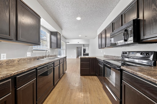 3237 Preston Dr, Midland, TX 79707 - kitchen featuring black appliances, a textured ceiling, dark brown cabinets, light wood-style floors, and dark countertops