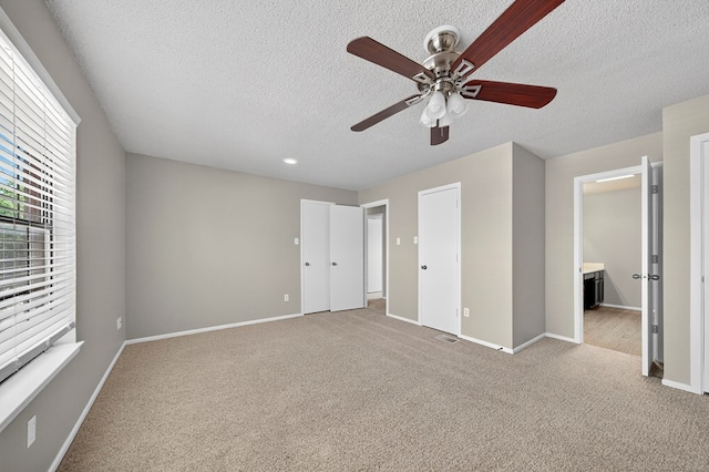 3237 Preston Dr, Midland, TX 79707 - unfurnished bedroom with a textured ceiling, carpet, connected bathroom, and ceiling fan