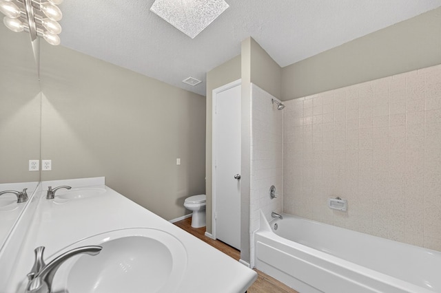 3237 Preston Dr, Midland, TX 79707 - bathroom with double vanity, wood finished floors,  shower combination, and a skylight
