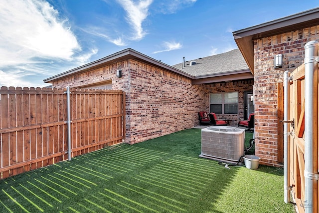 view of yard with central air condition unit and fence