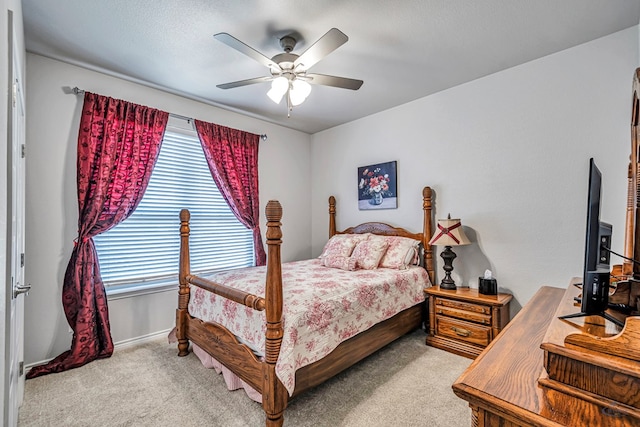 bedroom featuring baseboards, light colored carpet, and ceiling fan