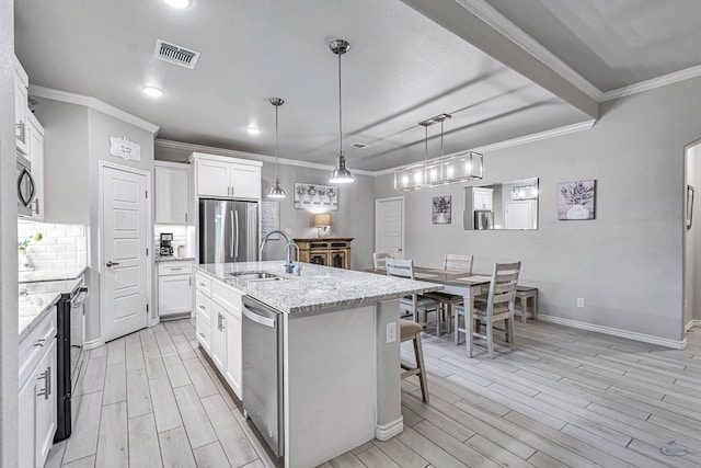 kitchen with visible vents, a sink, tasteful backsplash, stainless steel appliances, and wood tiled floor