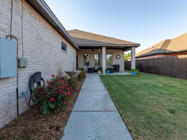 view of yard featuring a patio, ceiling fan, and a fenced backyard
