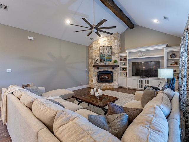 living area with a fireplace, wood finished floors, ceiling fan, and vaulted ceiling with beams