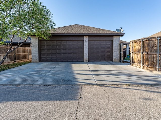 garage with driveway and fence