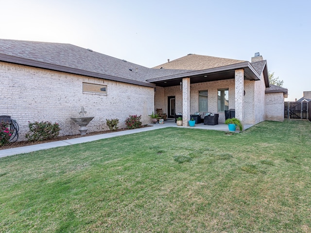rear view of house with a patio, a chimney, outdoor lounge area, fence, and a yard