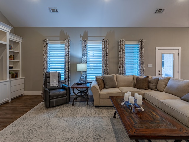 living room featuring visible vents, vaulted ceiling, wood finished floors, and baseboards
