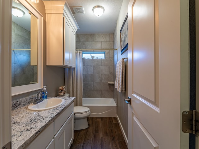 full bath with vanity, shower / bath combo with shower curtain, toilet, visible vents, and wood finished floors