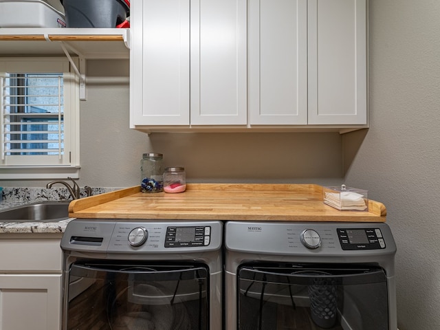 laundry room with a sink, cabinet space, and washer and clothes dryer