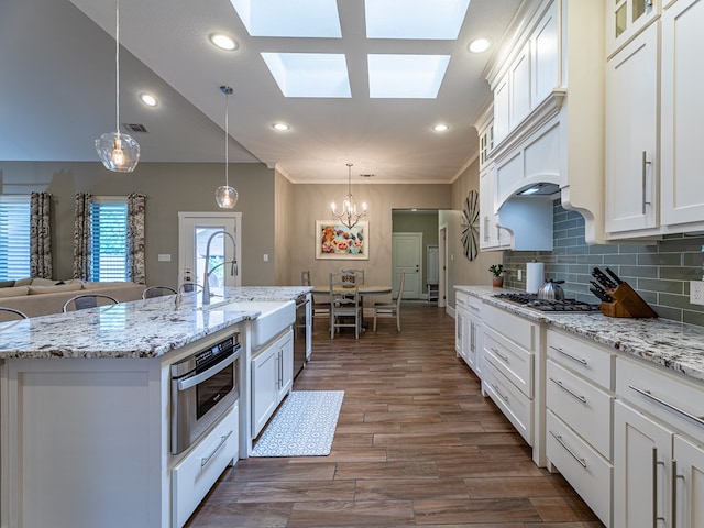 kitchen featuring recessed lighting, stainless steel appliances, white cabinets, and a sink