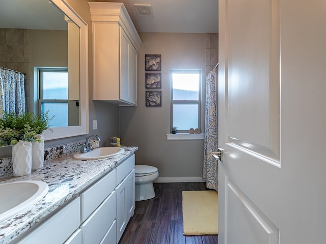 bathroom with visible vents, wood finished floors, plenty of natural light, and a sink