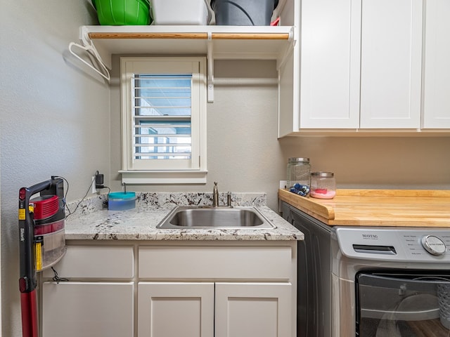 washroom with washer / clothes dryer, cabinet space, and a sink