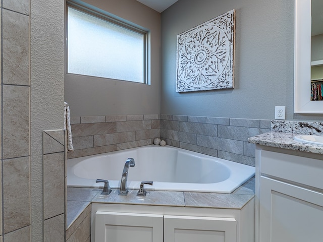 full bathroom featuring a bath and vanity