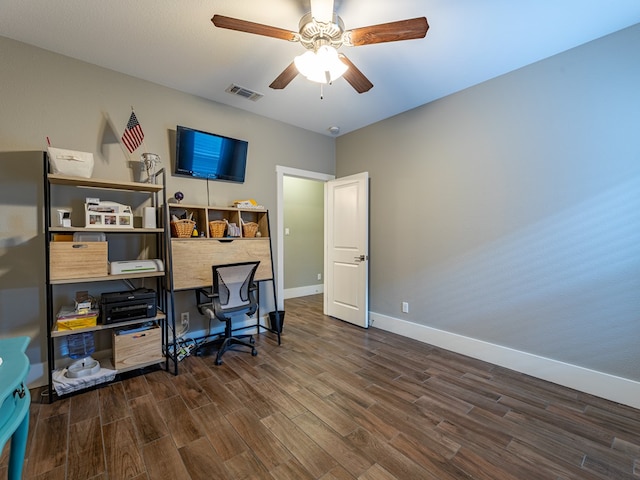 home office featuring baseboards, visible vents, a ceiling fan, and dark wood-type flooring