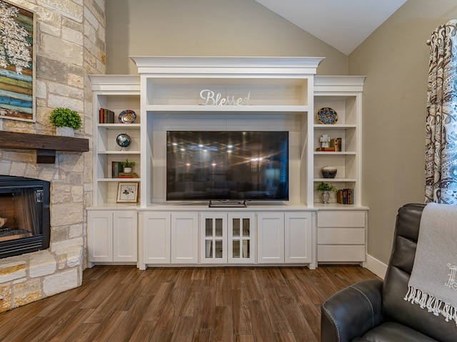 living area featuring dark wood-style flooring, a fireplace, and vaulted ceiling