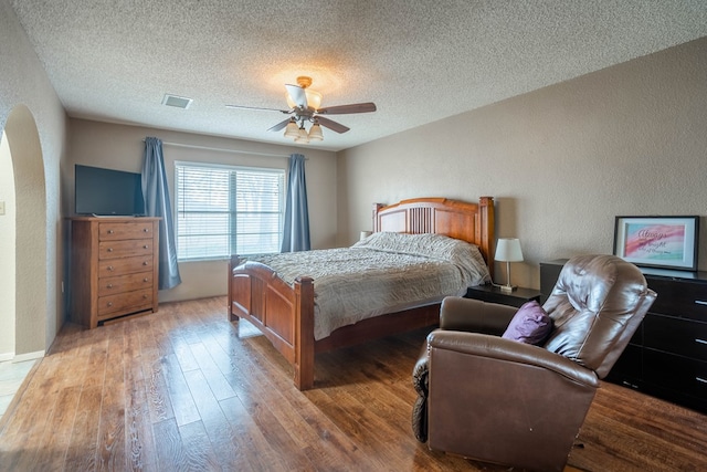 bedroom featuring wood-type flooring, a textured ceiling, and ceiling fan