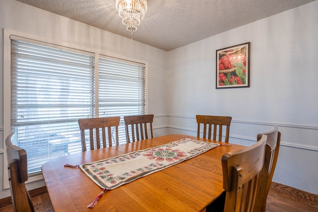 dining room featuring an inviting chandelier and a textured ceiling