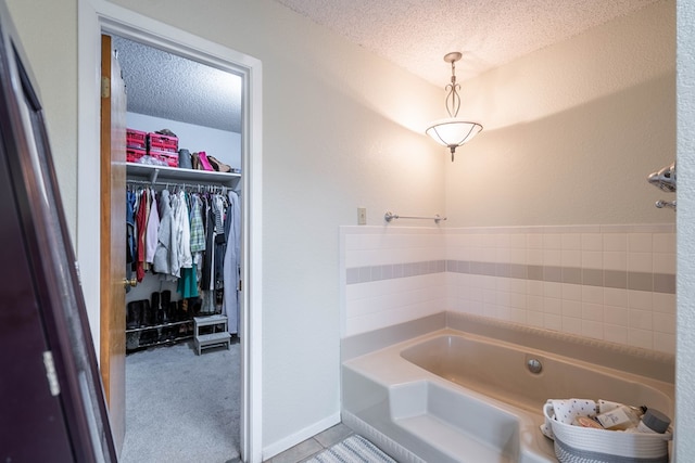 bathroom featuring a tub to relax in and a textured ceiling