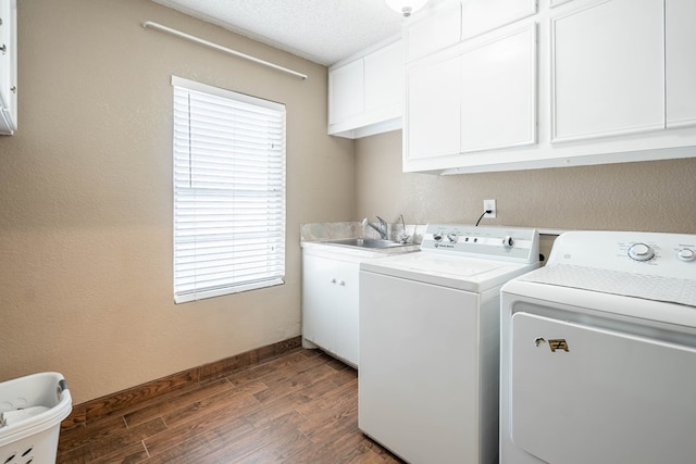 laundry area with sink, washing machine and dryer, cabinets, a healthy amount of sunlight, and dark hardwood / wood-style flooring