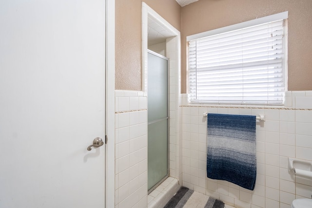 bathroom with tile walls, an enclosed shower, and a fireplace