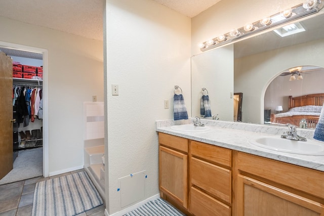 bathroom with tile patterned floors, a textured ceiling, vanity, a bathtub, and ceiling fan