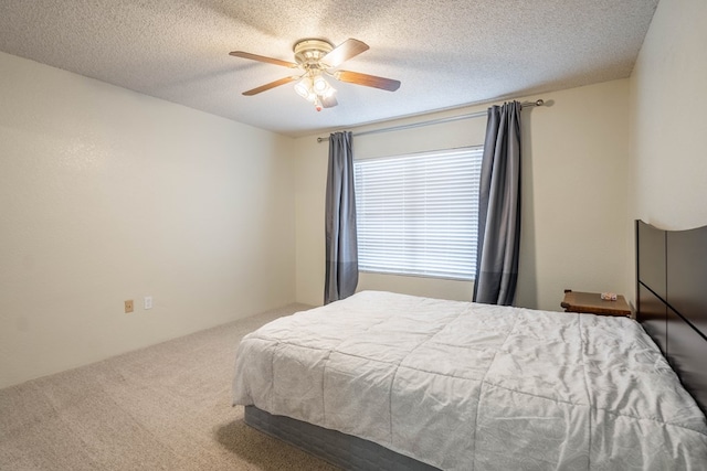 bedroom with ceiling fan, carpet, and a textured ceiling