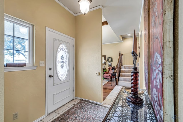 tiled foyer entrance with crown molding