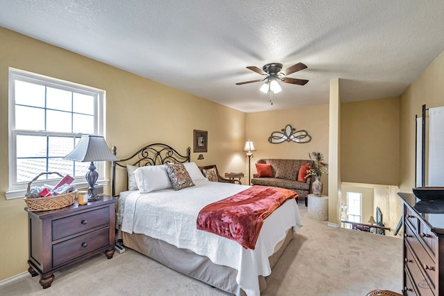 carpeted bedroom with ceiling fan and a textured ceiling