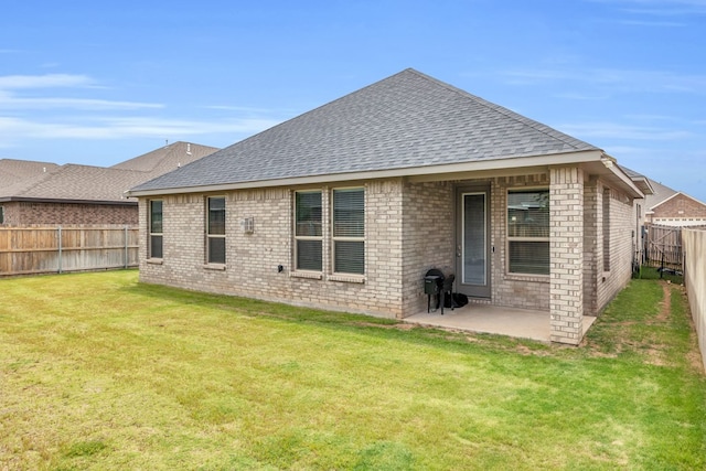 rear view of house featuring roof with shingles, a patio area, and brick siding