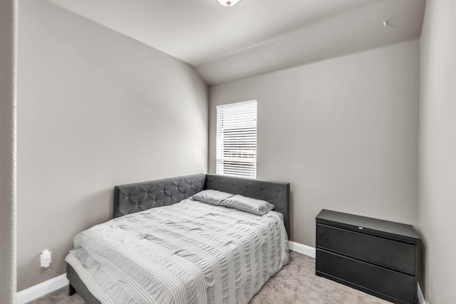 carpeted bedroom with baseboards and lofted ceiling