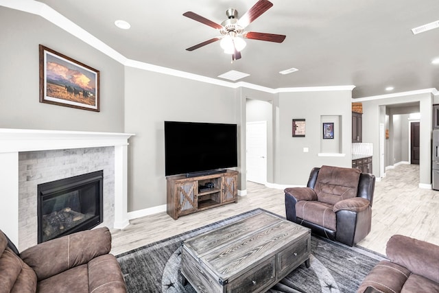 living room featuring light wood-type flooring, a ceiling fan, a glass covered fireplace, baseboards, and recessed lighting