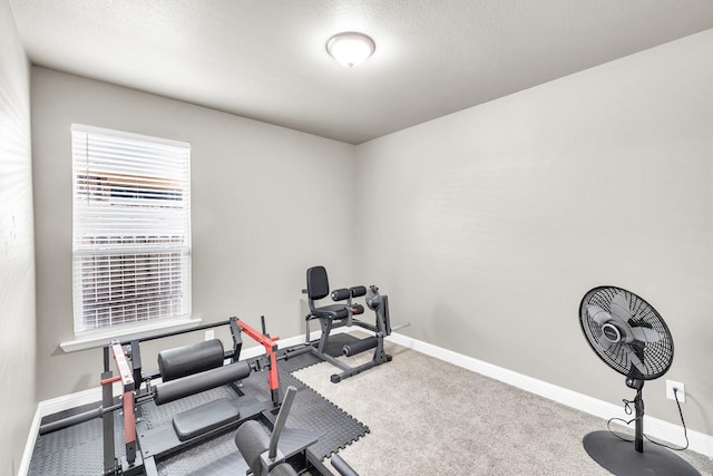 workout room with baseboards and carpet floors