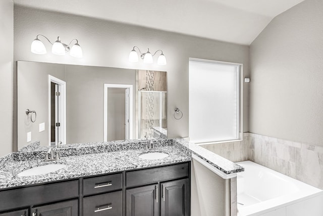 full bath featuring a shower stall, double vanity, a bath, and vaulted ceiling