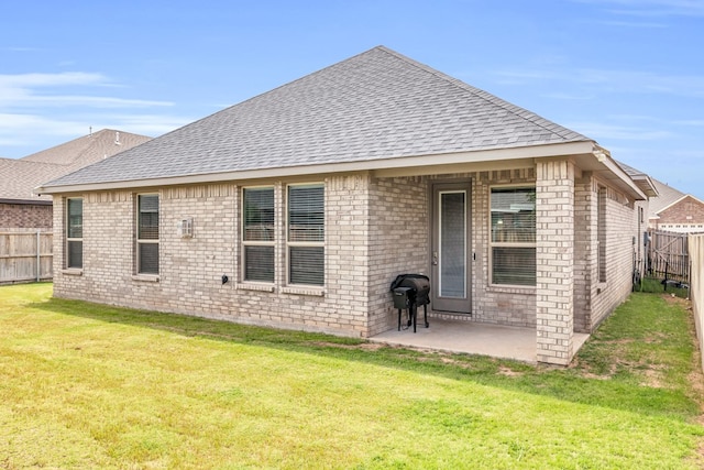 back of house featuring roof with shingles, a patio area, and brick siding
