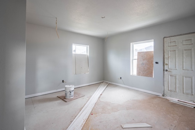 unfurnished room with baseboards