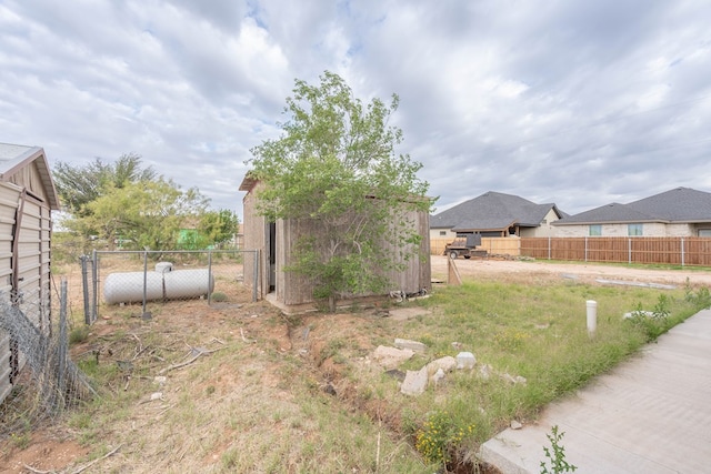 view of yard featuring fence, a storage shed, and an outbuilding