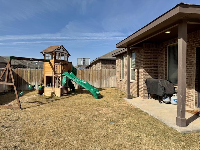 view of jungle gym with fence, a patio, and a yard