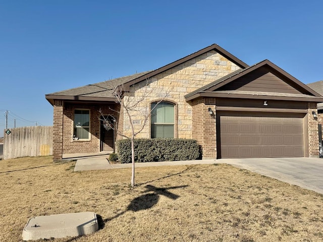 view of front of house with a garage, concrete driveway, brick siding, and fence