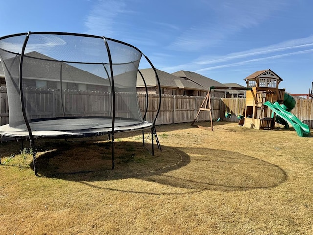 view of playground with a trampoline and fence