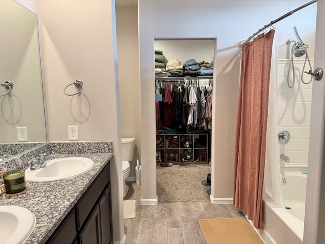 full bath featuring double vanity, toilet, shower / bathtub combination with curtain, a walk in closet, and a sink