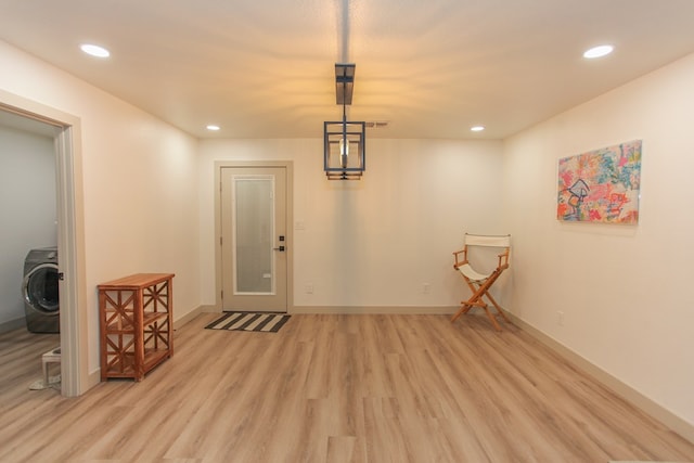 interior space with washer / dryer and light hardwood / wood-style flooring