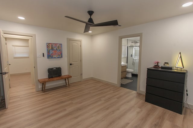 bedroom featuring ceiling fan, ensuite bath, and light wood-type flooring