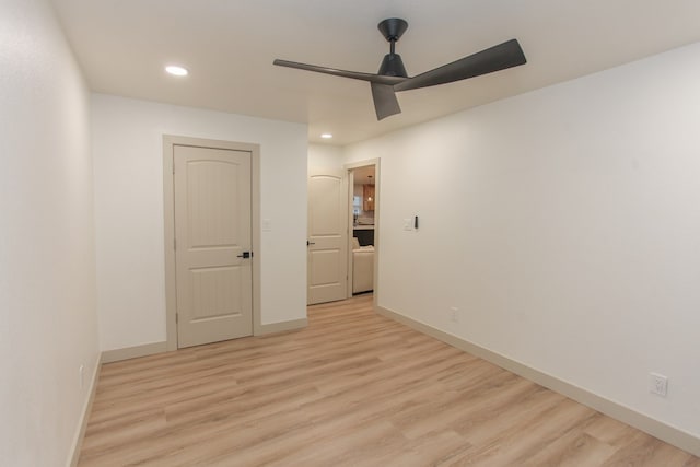 empty room with ceiling fan and light hardwood / wood-style flooring