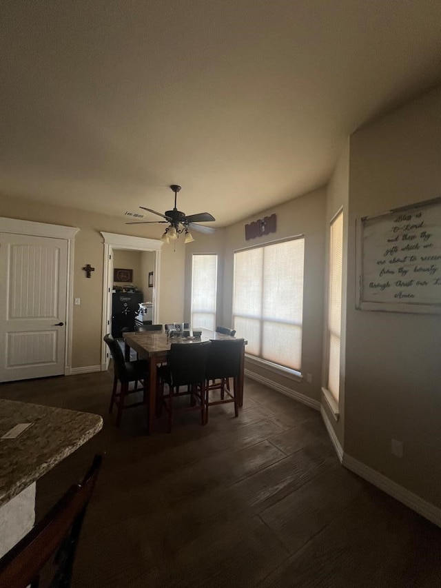 dining space with dark wood-type flooring and ceiling fan