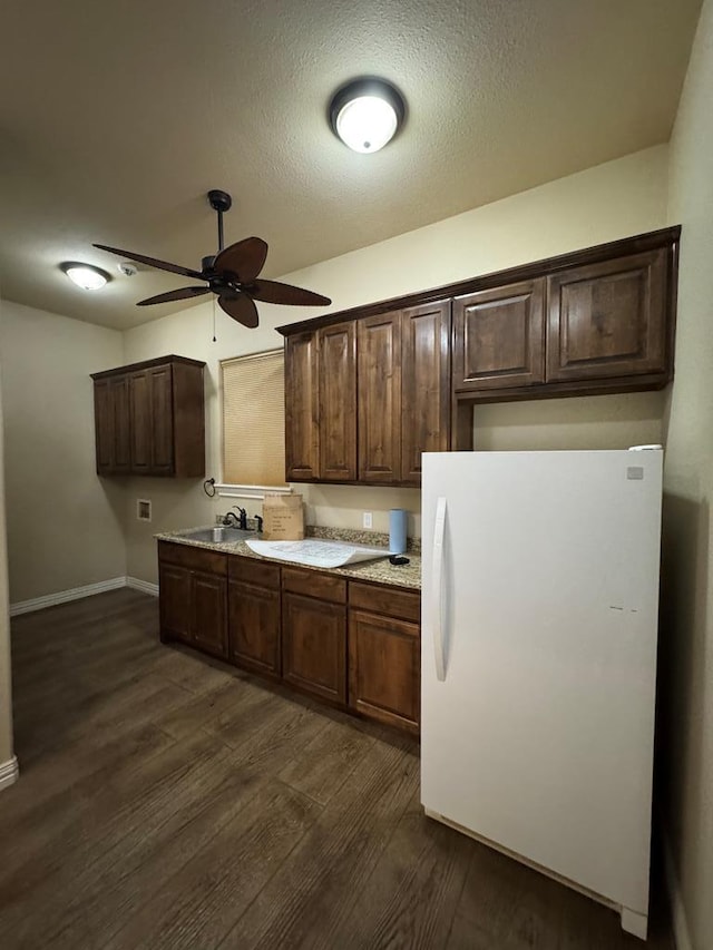 kitchen featuring dark hardwood / wood-style flooring, white refrigerator, ceiling fan, dark brown cabinets, and a textured ceiling